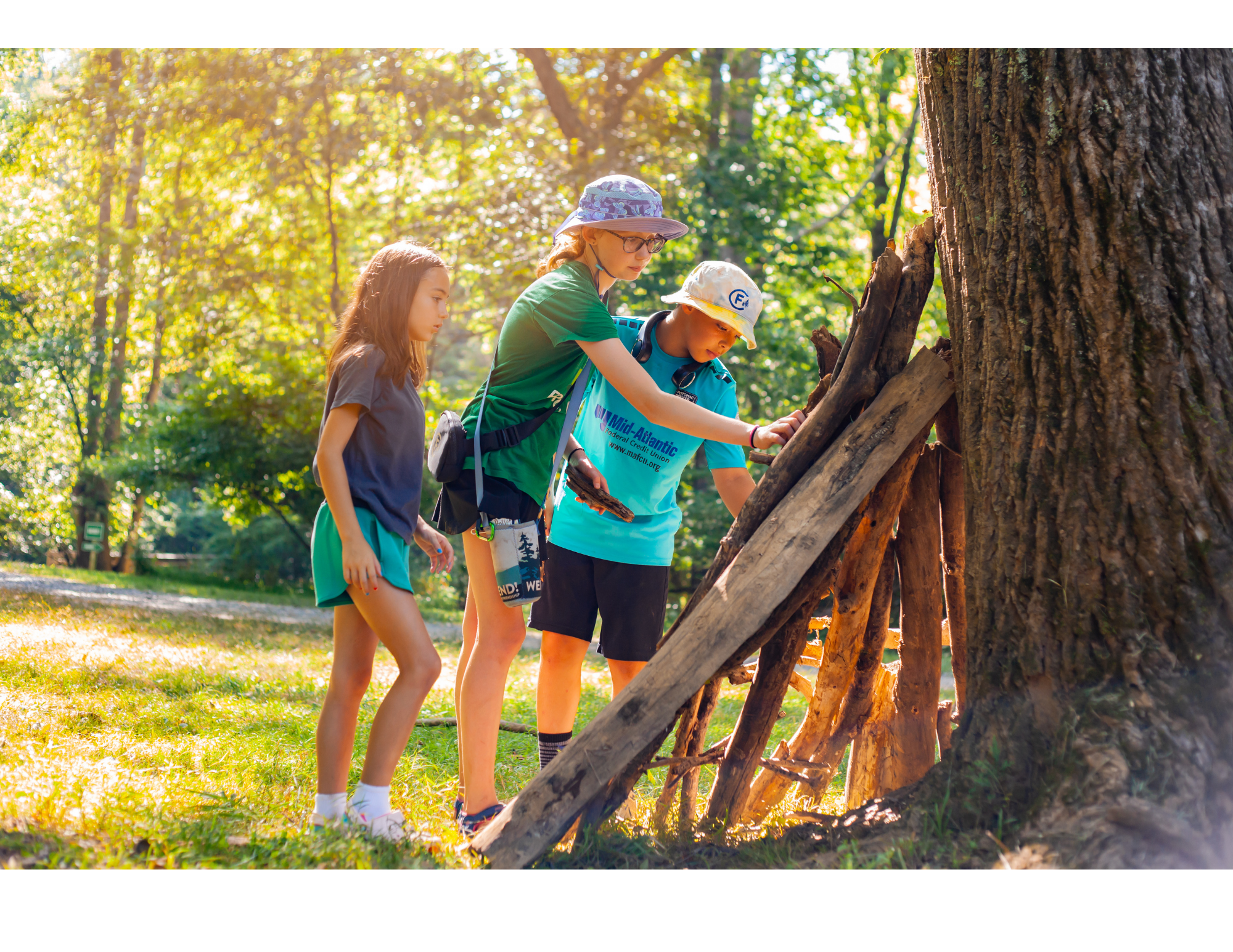 Children building a wooden structure outdoors at camp