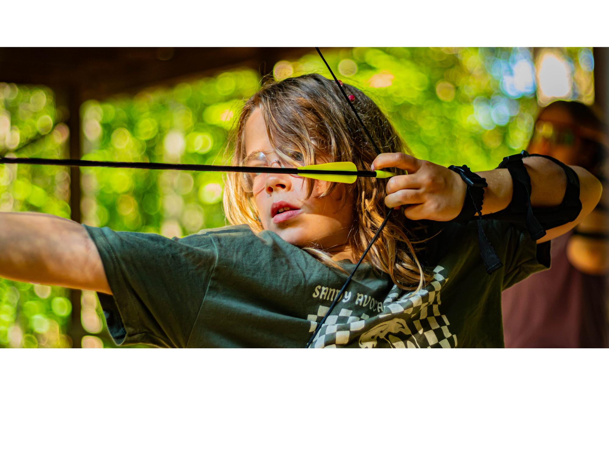 Child doing archery at summer camp